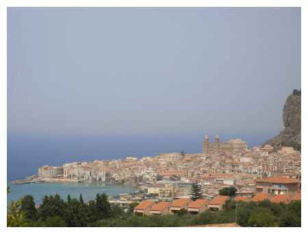 L'immagine classica di Cefalù. Il paese è appoggiato ad una rocca. Un piccolo promontorio sul mare. In evidenza il duomo in stile romanico con i 2 caratteristici campanili. La cittadina si sviluppa a dr il vero anche lateralmente. In foto si vede solo il paese antico.